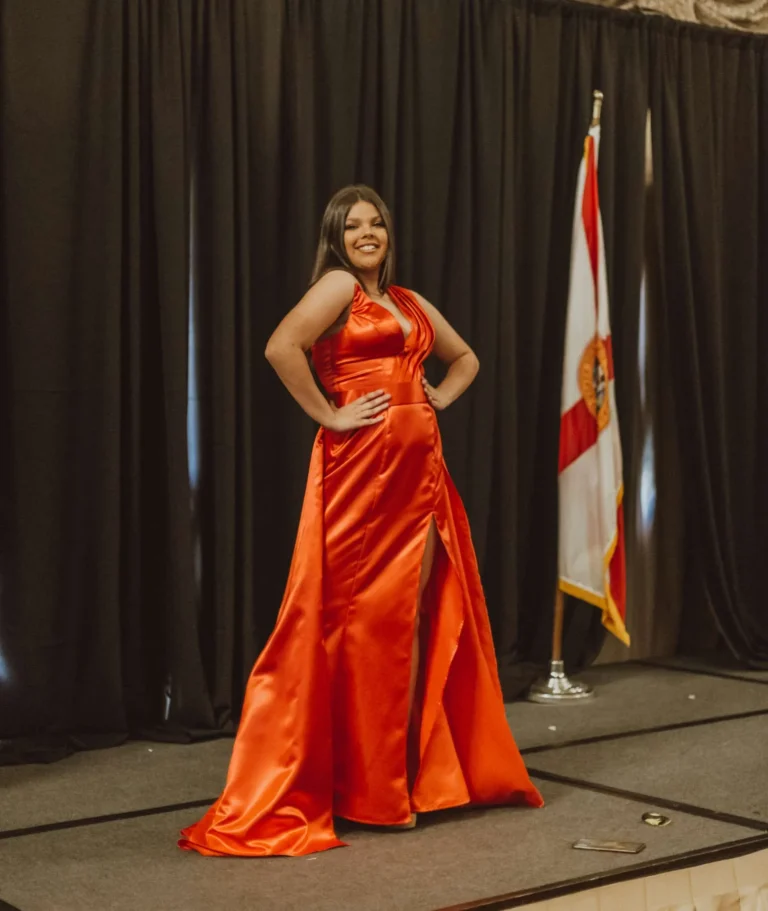 This is an image of a lady wearing a custom made formal dress made by Betzabe Pujaico Designs in North Miami, FL.